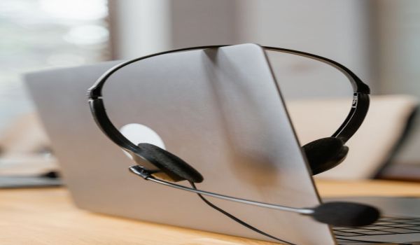 Услуги Headset on a laptop symbolizes remote work and communication efficiency.