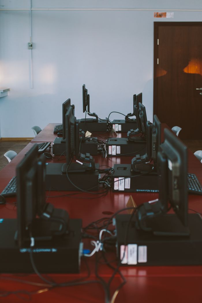 A modern computer lab featuring multiple workstations on a wooden desk in a quiet room.